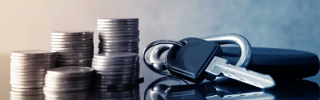 Stacks of coins beside a set of car keys on a reflective surface, symbolizing financial offers, savings, or vehicle deals.