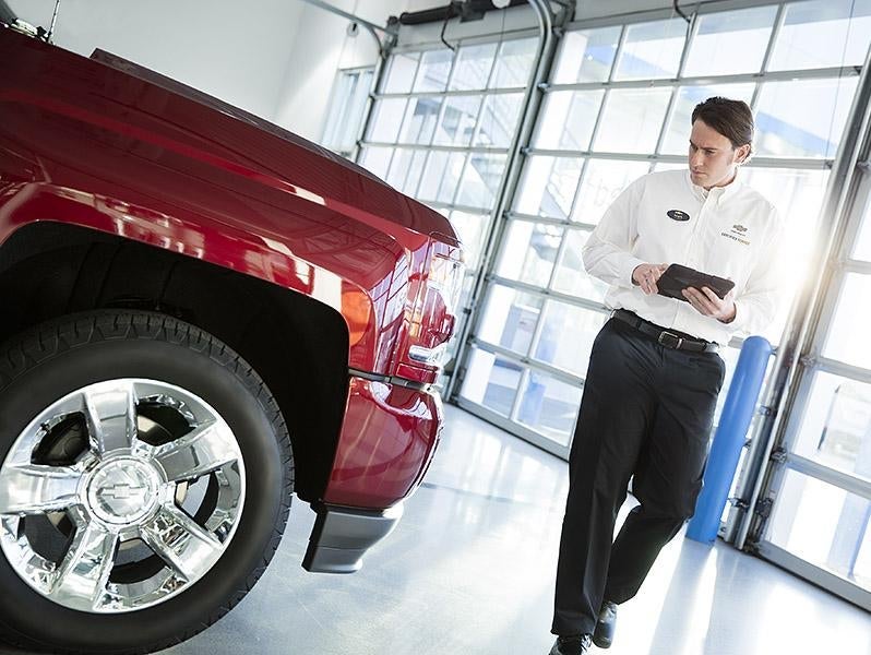 technician performing inspection of outside of a vehicle