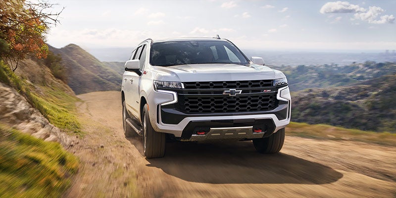 White 2021 Chevy Tahoe driving on dirt road